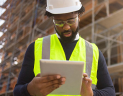 A black man contractor using tablet phone